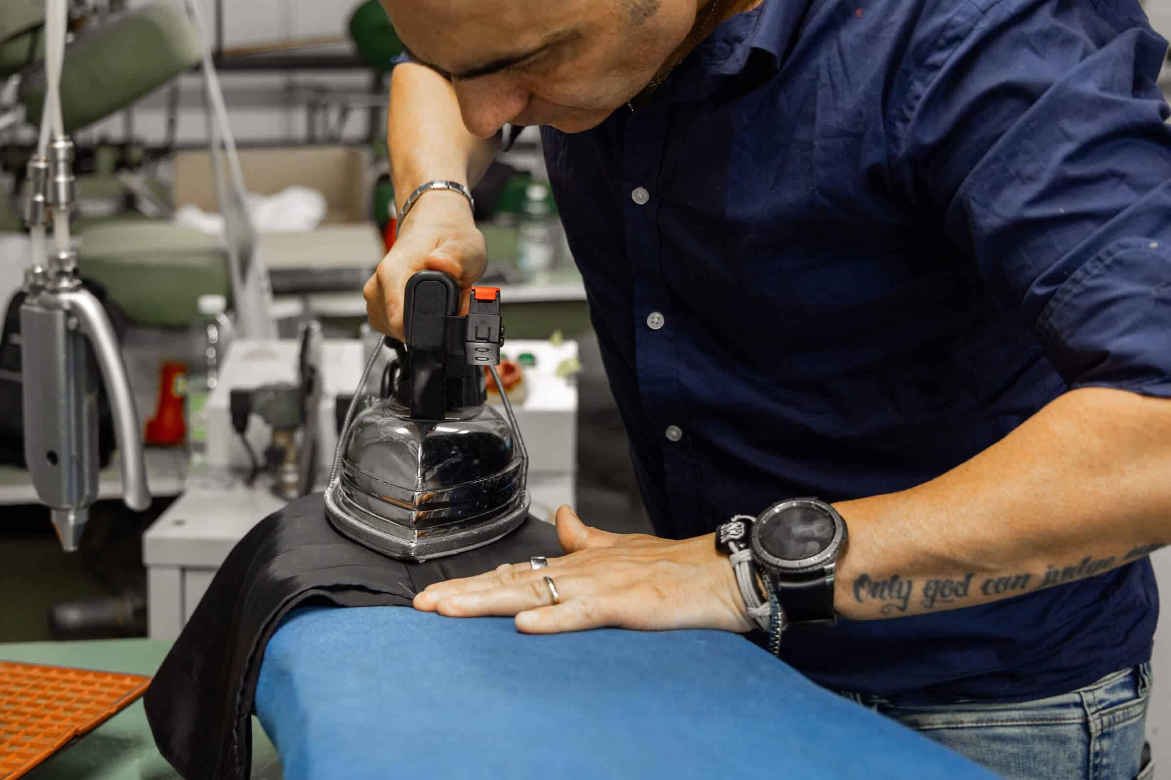 Image of a tailor ironing a finished suit